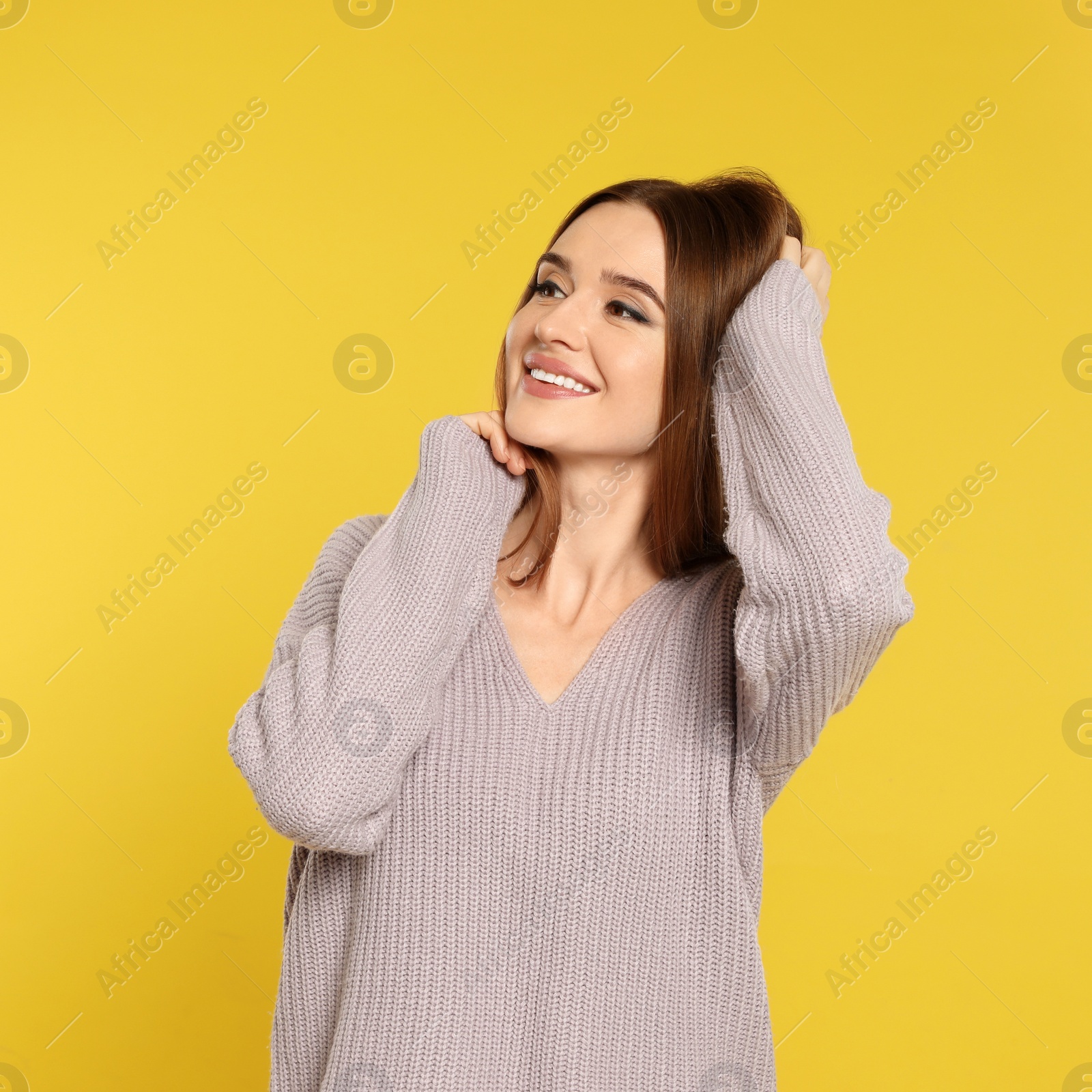 Photo of Beautiful young woman in sweater on yellow background. Winter season