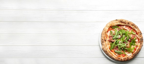 Tasty pizza with meat and arugula on white wooden table, top view with space for text. Banner design