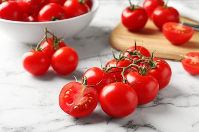 Branch of fresh cherry tomatoes on marble background