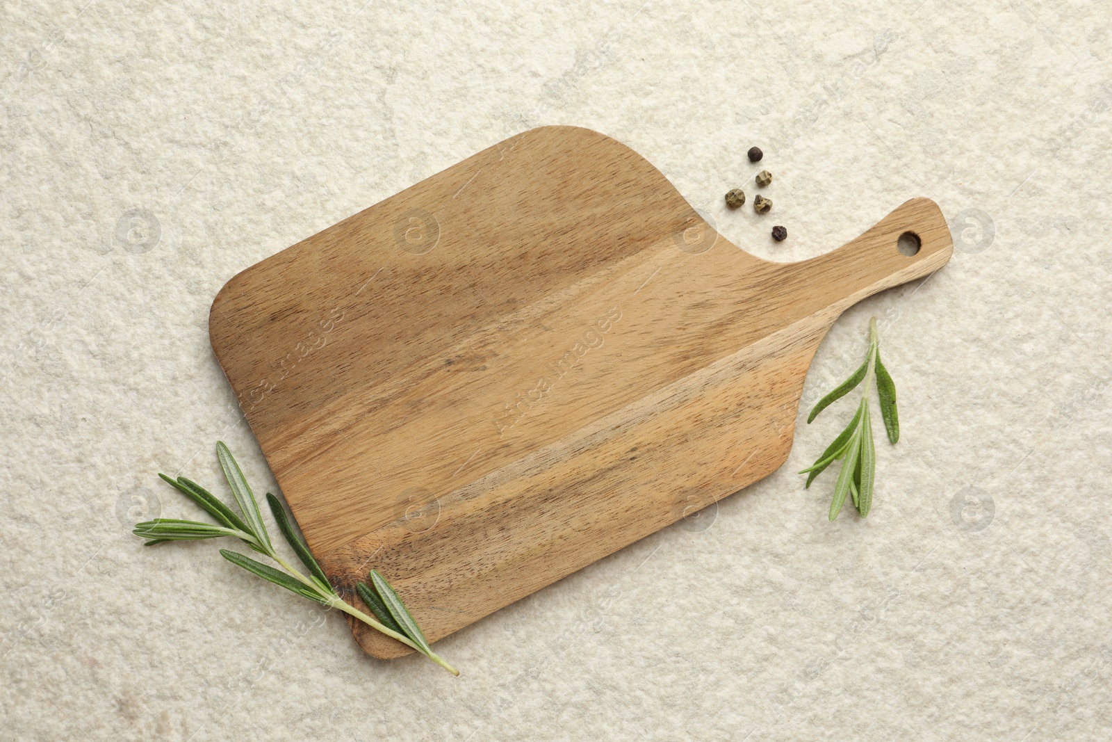 Photo of Cutting board, pepper and rosemary on white textured table, flat lay. Space for text