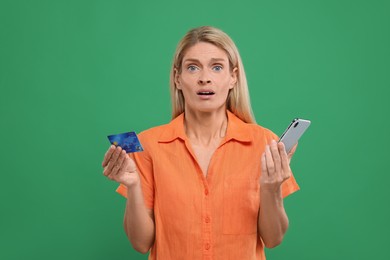 Photo of Stressed woman with credit card and smartphone on green background. Be careful - fraud