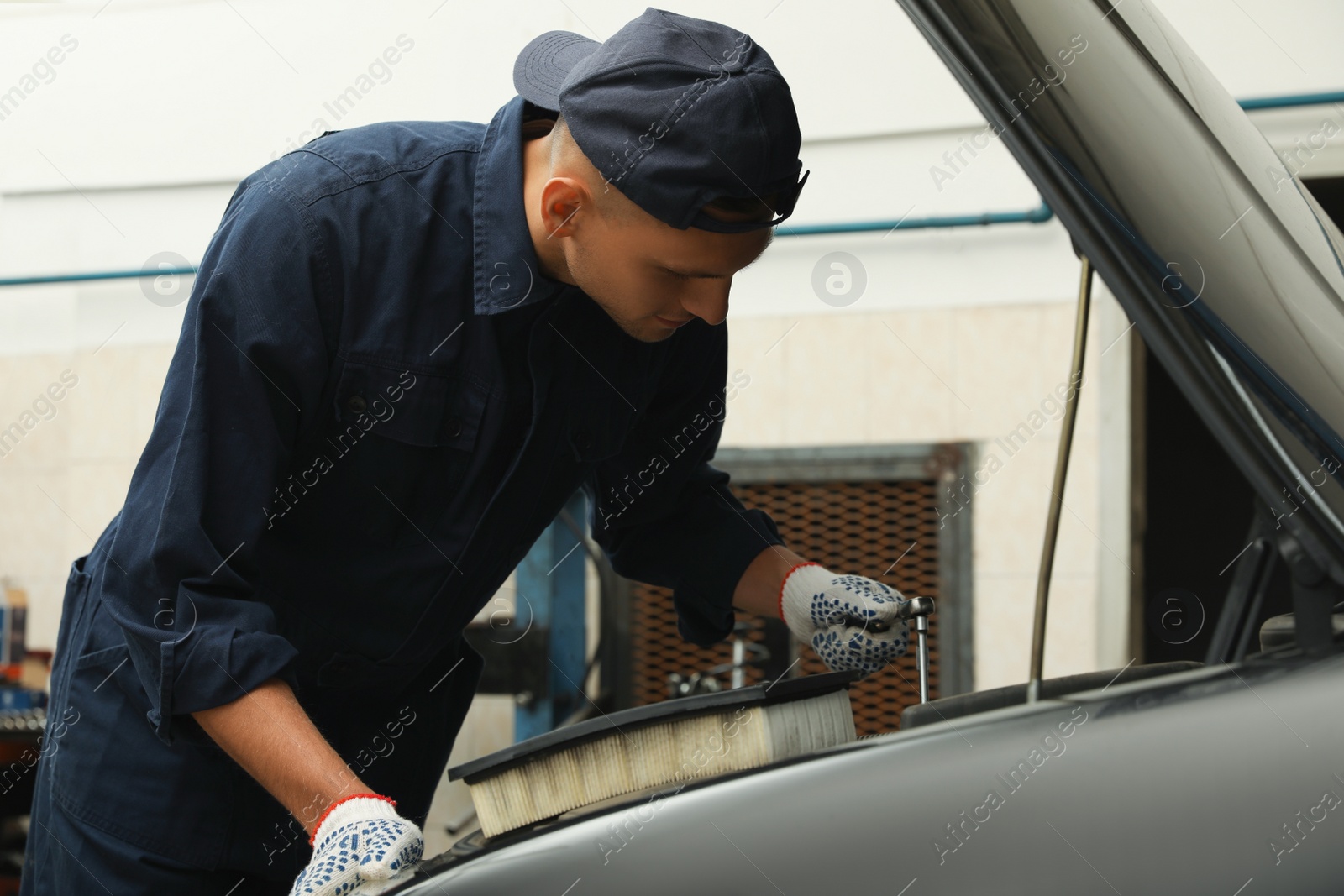 Photo of Professional mechanic fixing modern car at automobile repair shop