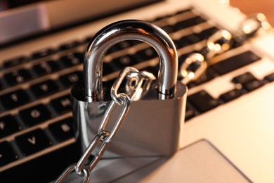 Photo of Cyber security. Padlock with chain on laptop, closeup