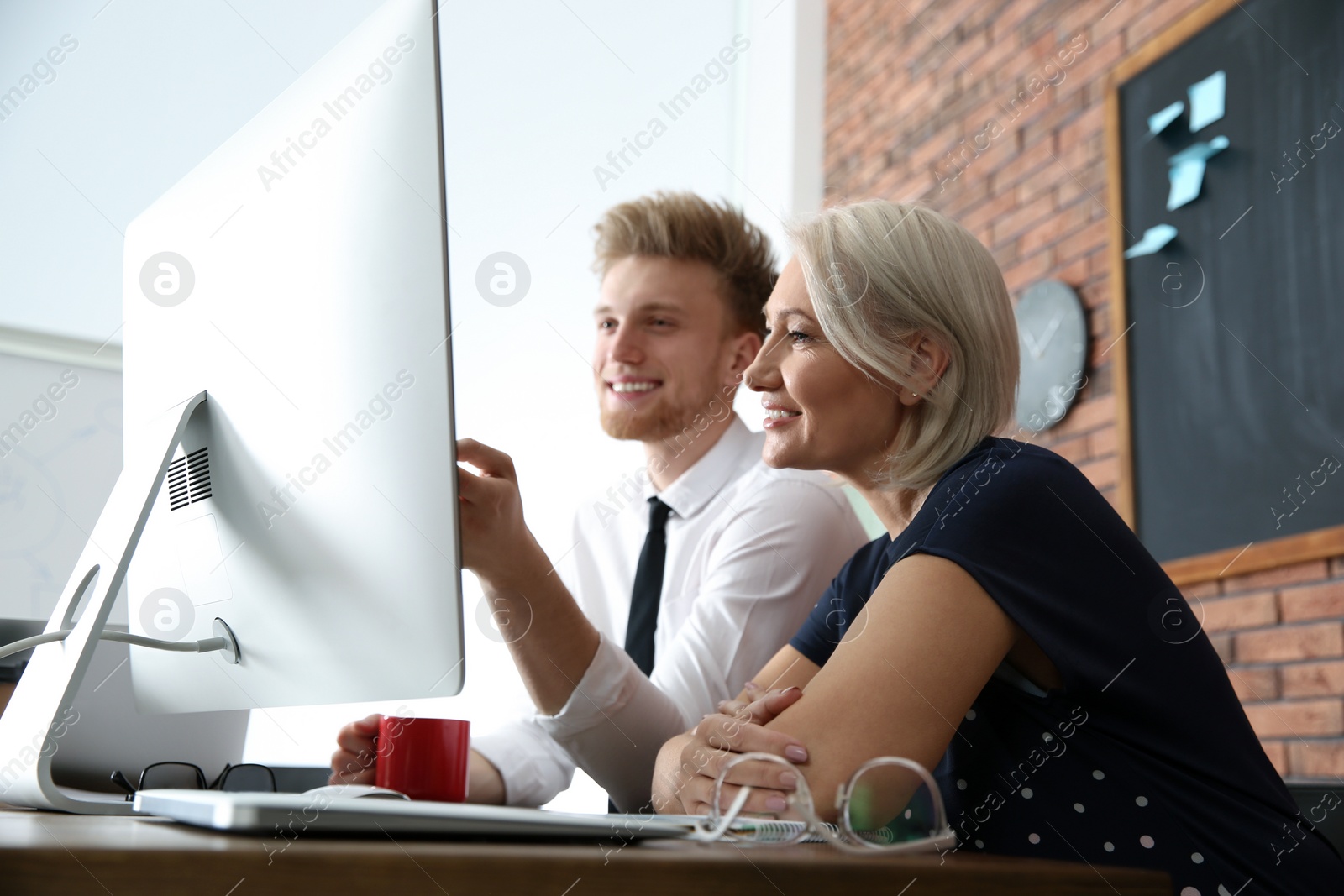 Photo of Business people working on computer at table in office. Professional communication