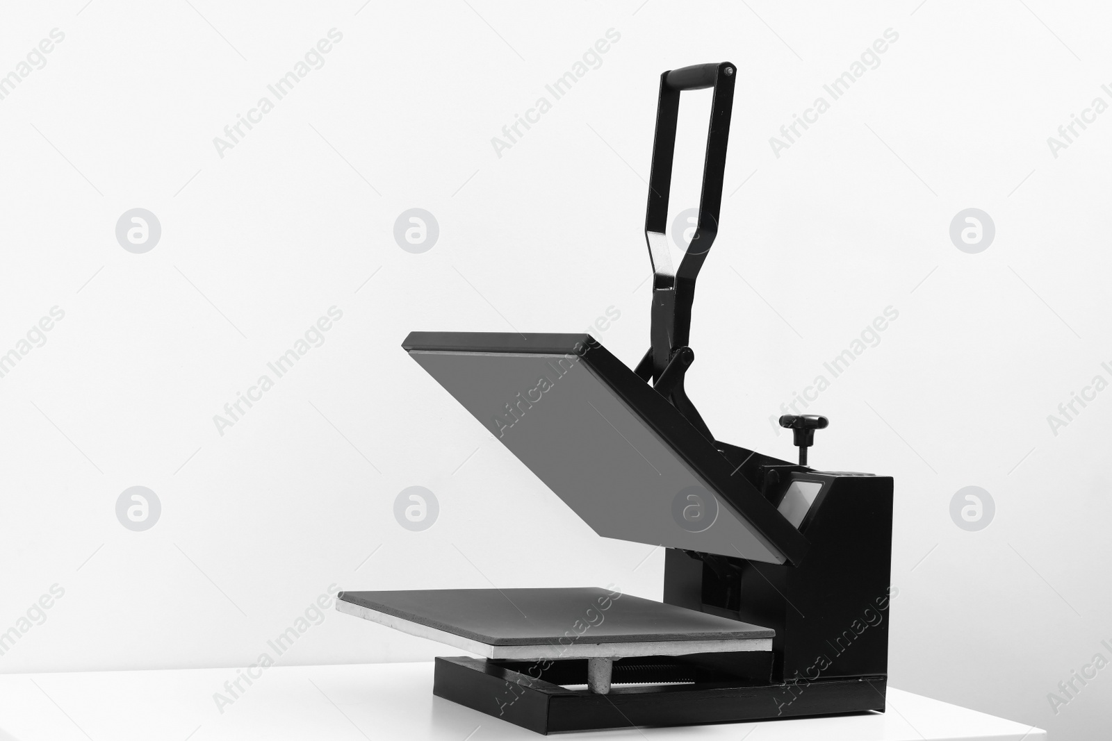 Photo of Heat press machine on table against light background