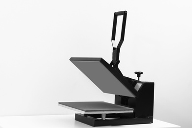 Photo of Heat press machine on table against light background