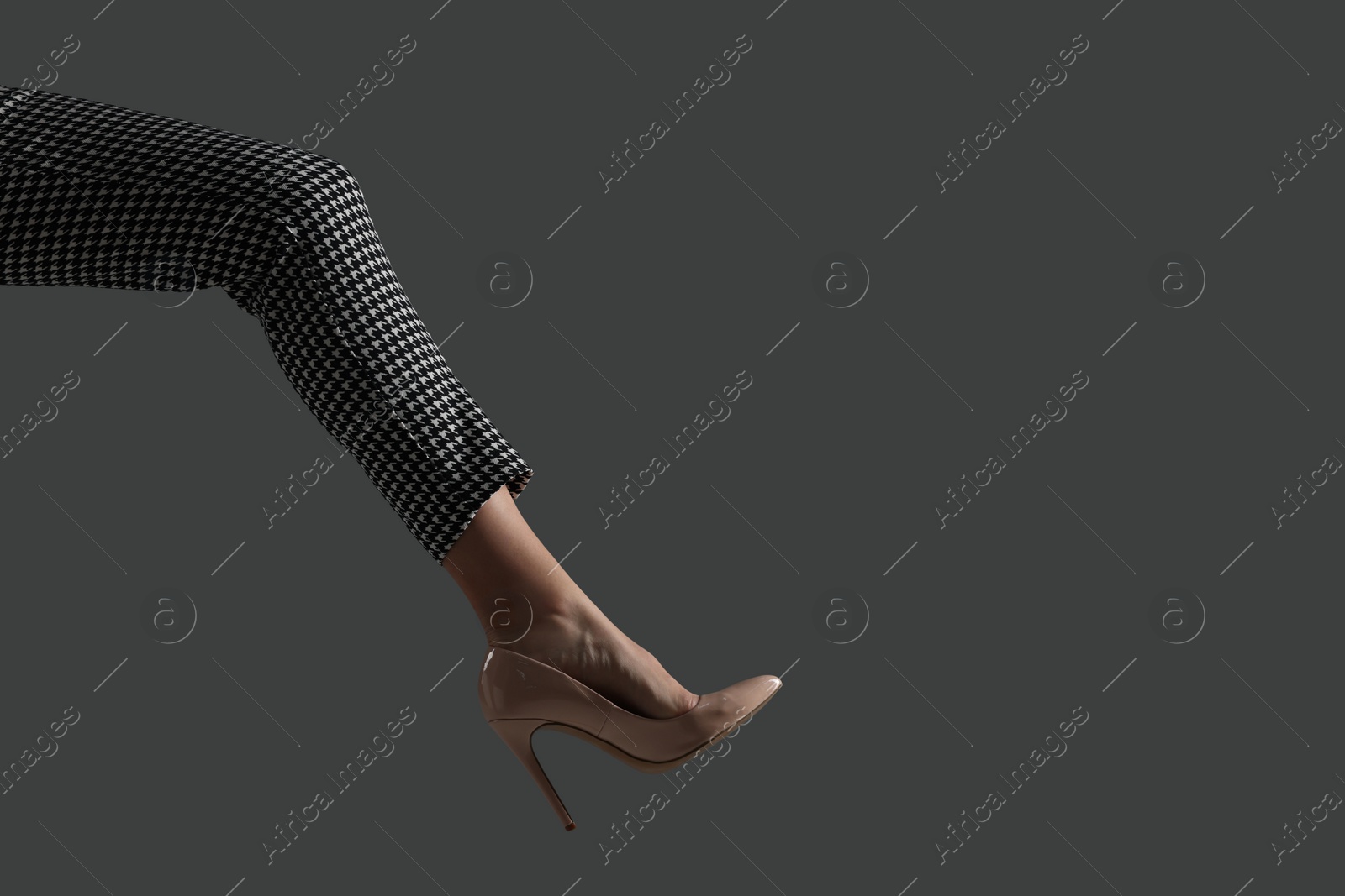 Photo of Businesswoman in beige shoe on grey background, closeup. Space for text