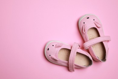 Cute baby shoes on pink background, flat lay. Space for text