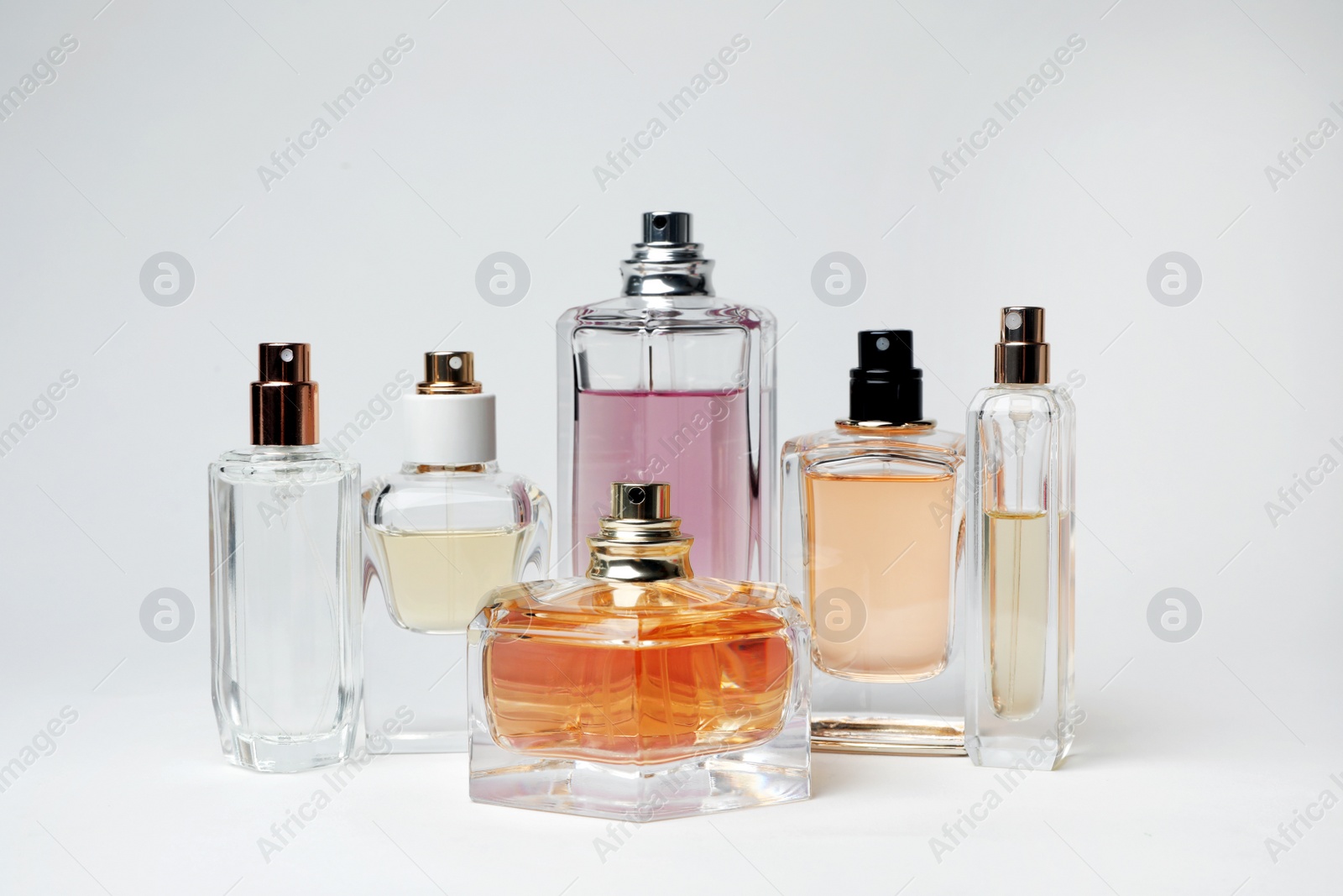 Photo of Transparent bottles of perfume on white background