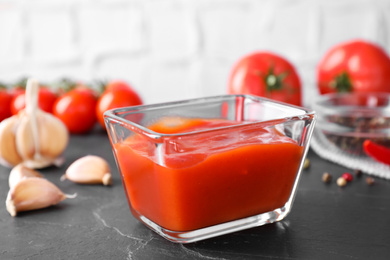 Photo of Delicious fresh tomato sauce on black table, closeup