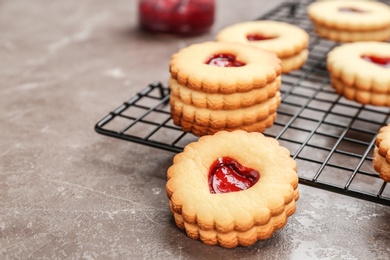 Photo of Traditional Christmas Linzer cookies with sweet jam on cooling rack