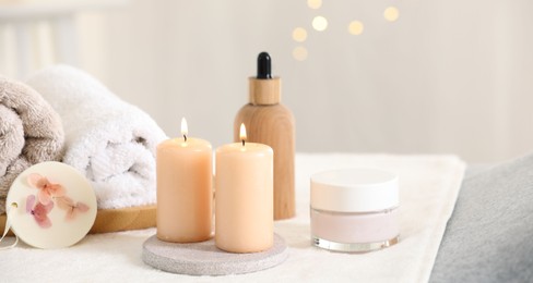 Spa composition. Burning candles and personal care products on soft surface