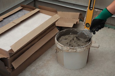 Photo of Worker taking adhesive mix with spatula, closeup