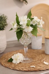 Photo of Beautiful jasmine flowers on wooden table indoors