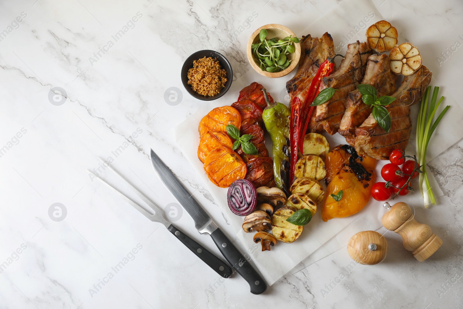 Photo of Delicious grilled meat and vegetables served on white marble table, flat lay