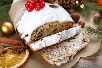 Traditional Christmas Stollen with icing sugar and cranberries on wooden table, closeup
