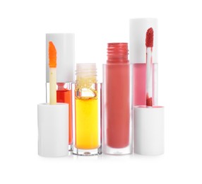 Photo of Different lip glosses and applicators isolated on white