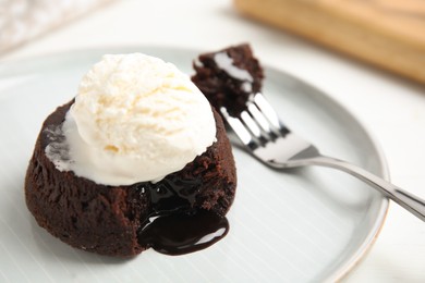 Photo of Delicious fresh fondant with hot chocolate and ice cream served on white table, closeup