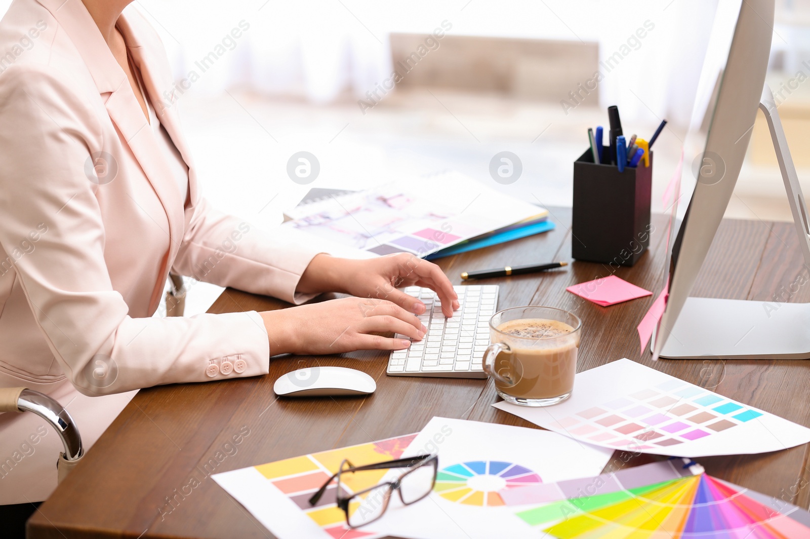 Photo of Female designer working at desk in office, closeup