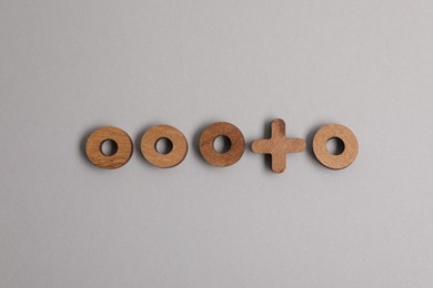 Photo of Choice concept. Wooden circles and cross on light grey background, flat lay