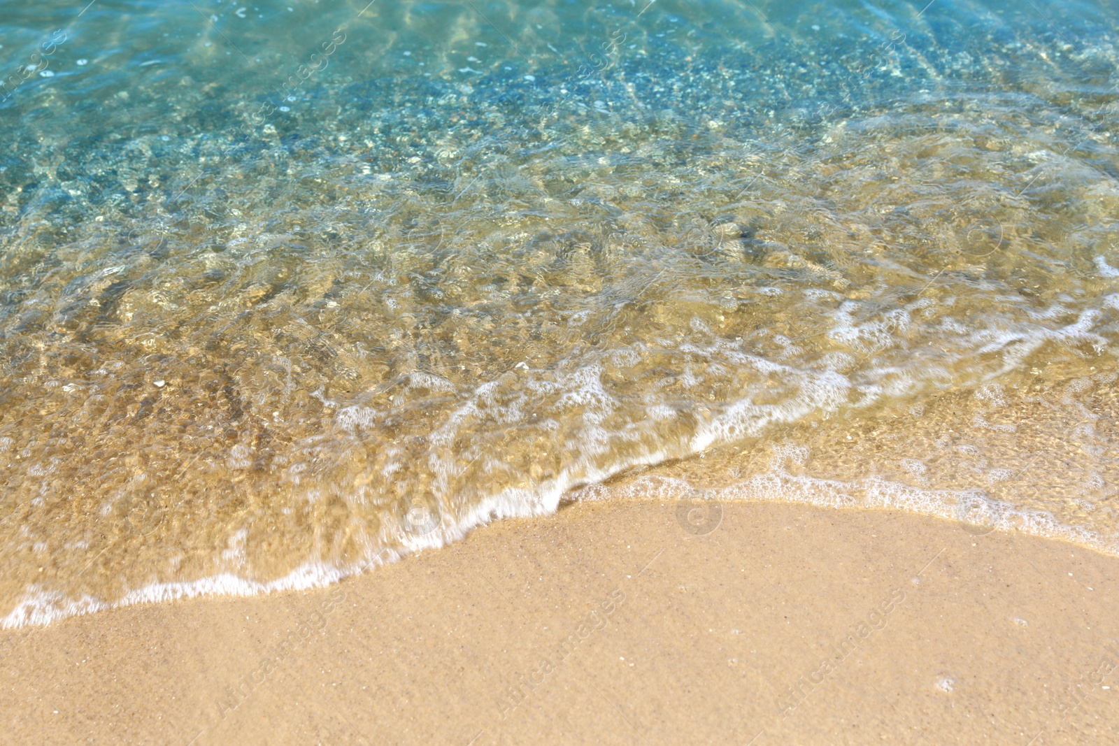 Photo of View of sea water and beach sand on sunny day