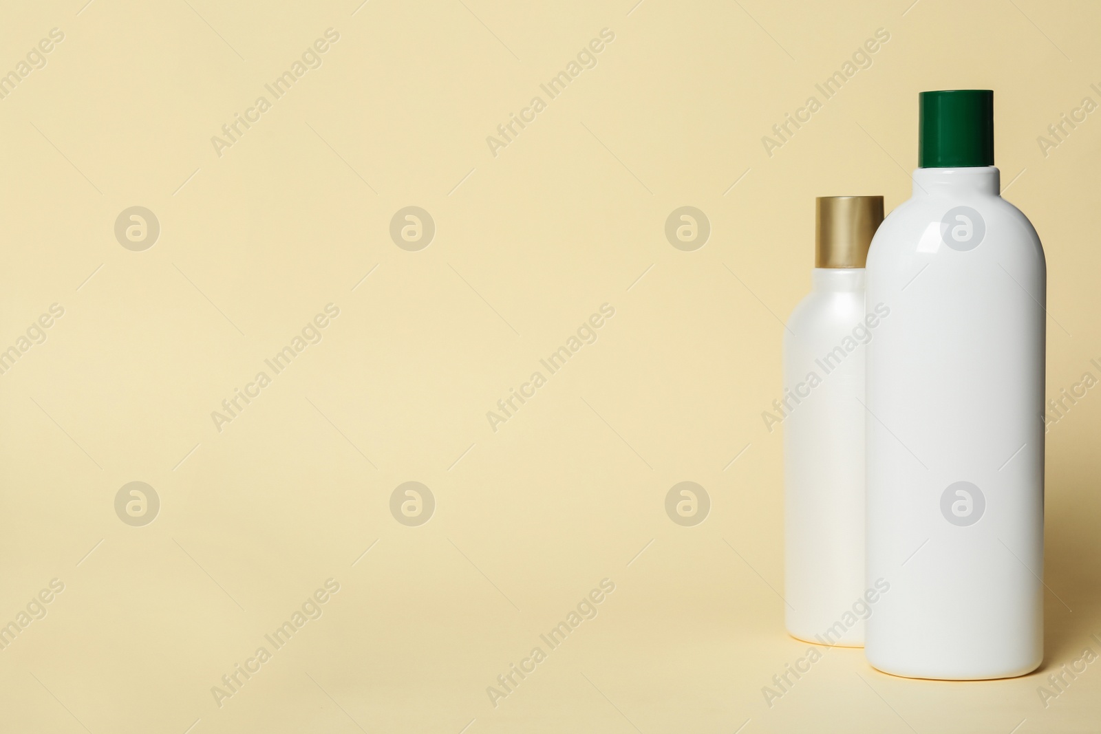 Photo of Bottles with cosmetic products on yellow background. Mockup for design