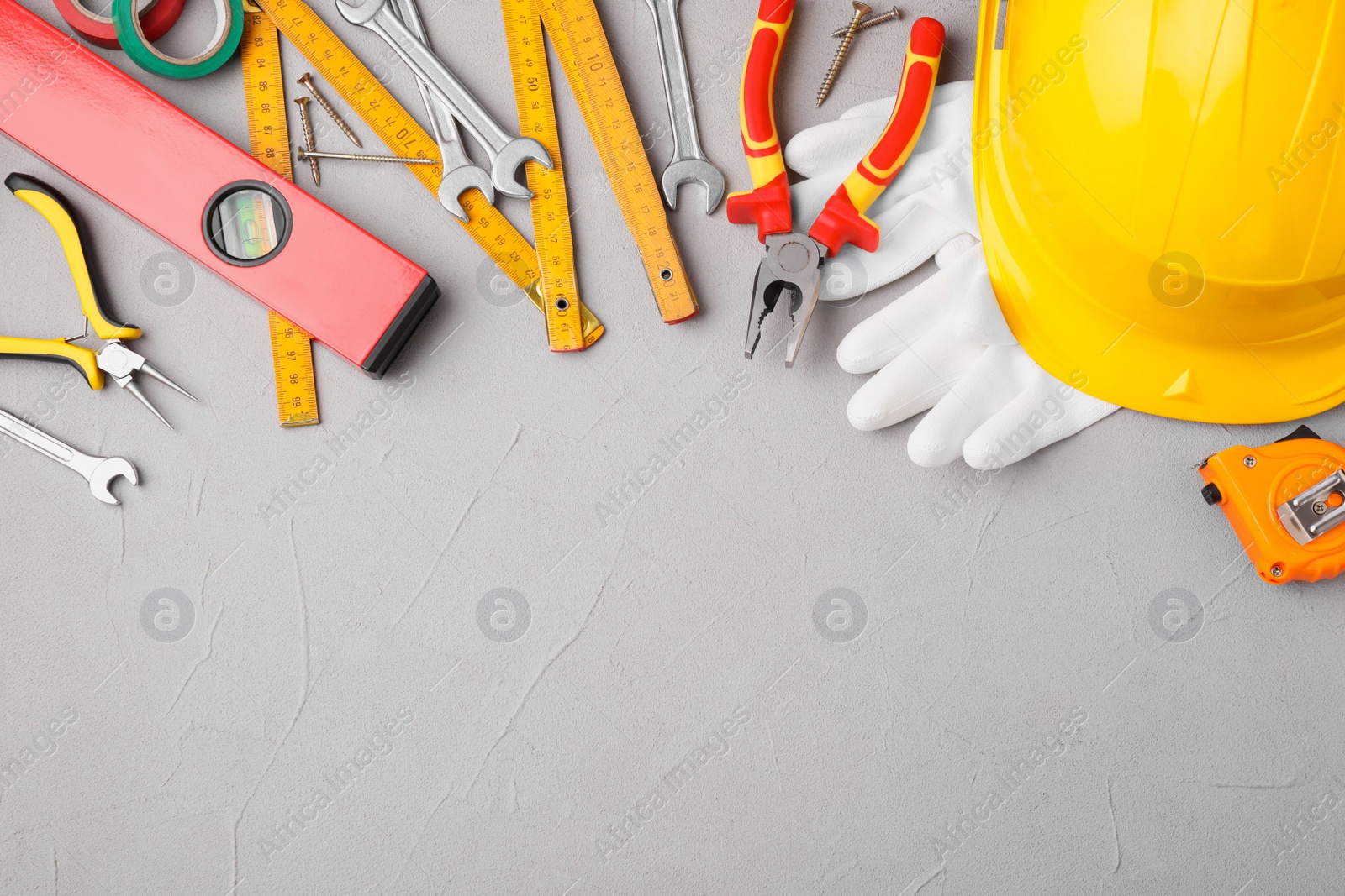 Photo of Flat lay composition with construction tools on light grey background. Space for text