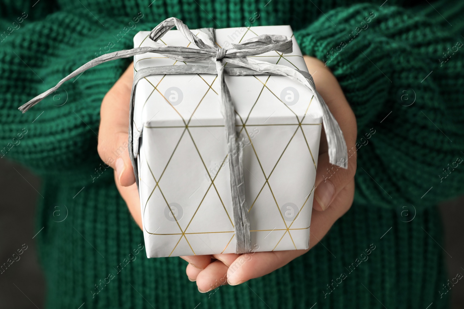 Photo of Woman holding beautiful Christmas gift with bow, closeup