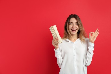 Young woman with delicious shawarma on red background, space for text