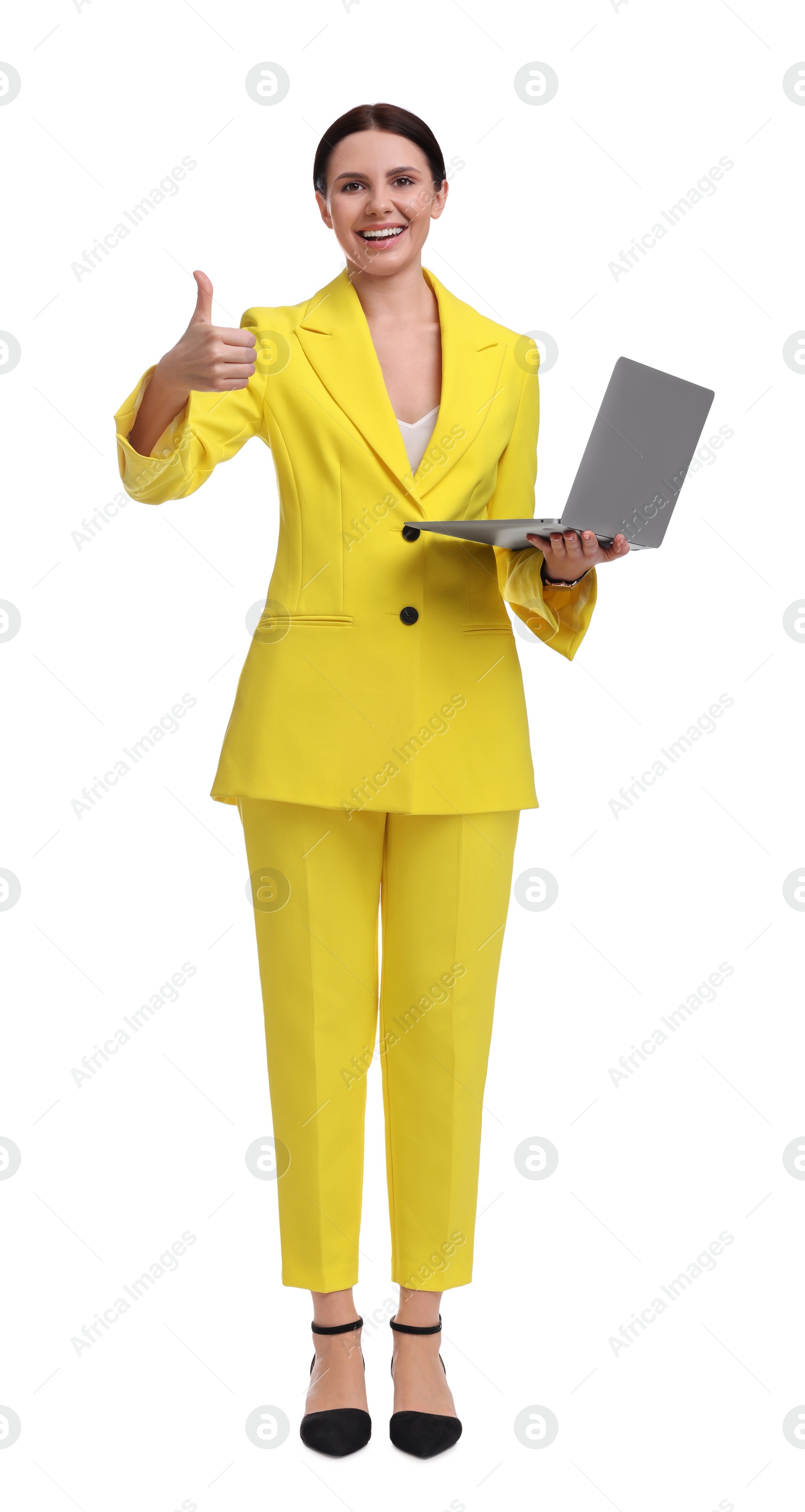 Photo of Beautiful businesswoman in yellow suit with laptop showing thumbs up on white background