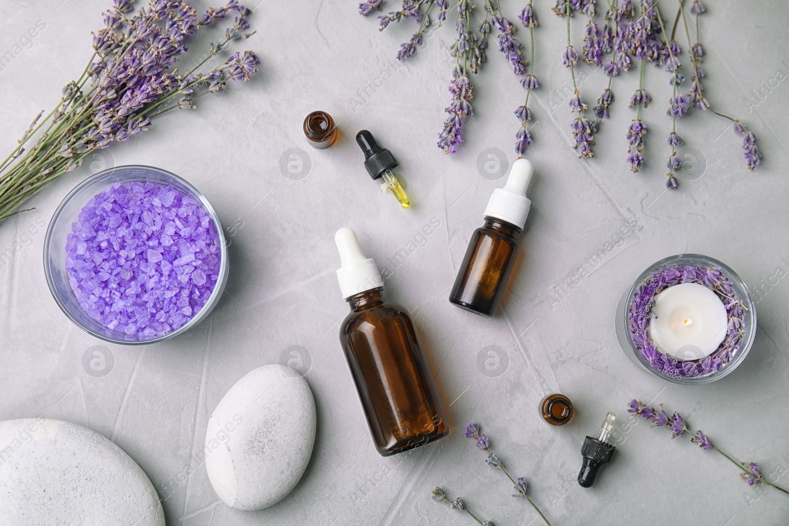 Photo of Flat lay composition with lavender flowers and natural cosmetic on grey background