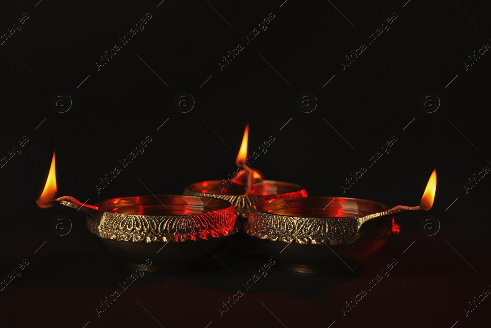 Photo of Diwali diyas or clay lamps on dark background