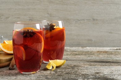 Aromatic punch drink and ingredients on wooden table. Space for text