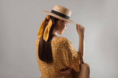 Photo of Woman with hat and stylish yellow bandana on light grey background