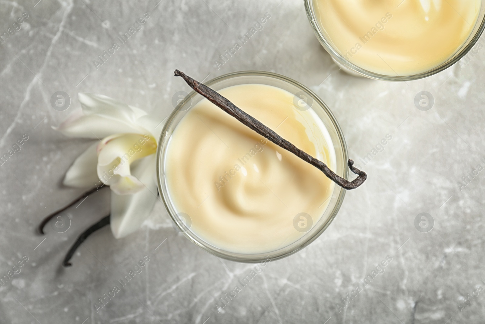 Photo of Vanilla pudding, sticks and flower on light background