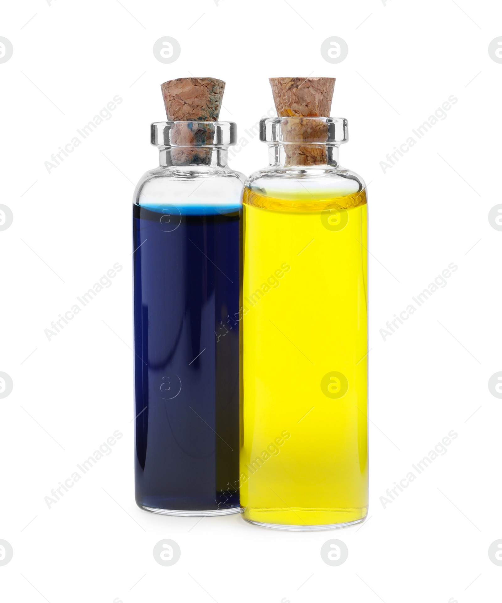 Photo of Glass bottles with different food coloring on white background