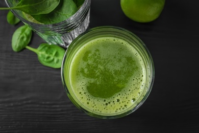 Photo of Glasses with delicious detox juice and ingredients on dark background, top view