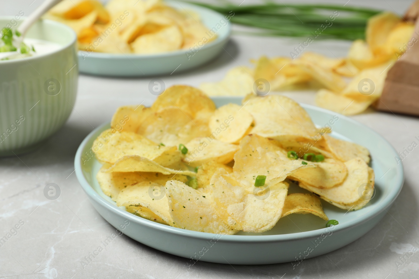 Photo of Chips and sour cream dressing on light grey table