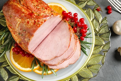 Plate with delicious ham served on grey table, above view. Christmas dinner