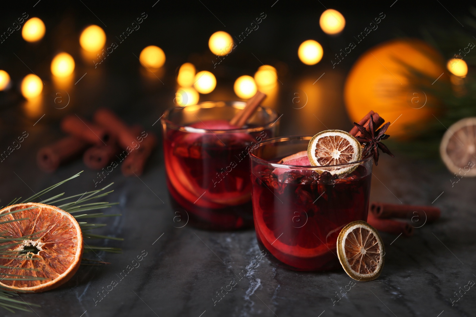 Photo of Mulled wine with cinnamon, anise and orange in glasses on table