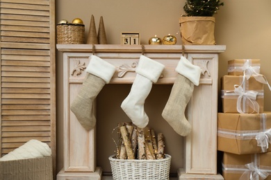 Photo of Fireplace with Christmas stockings in festive room interior