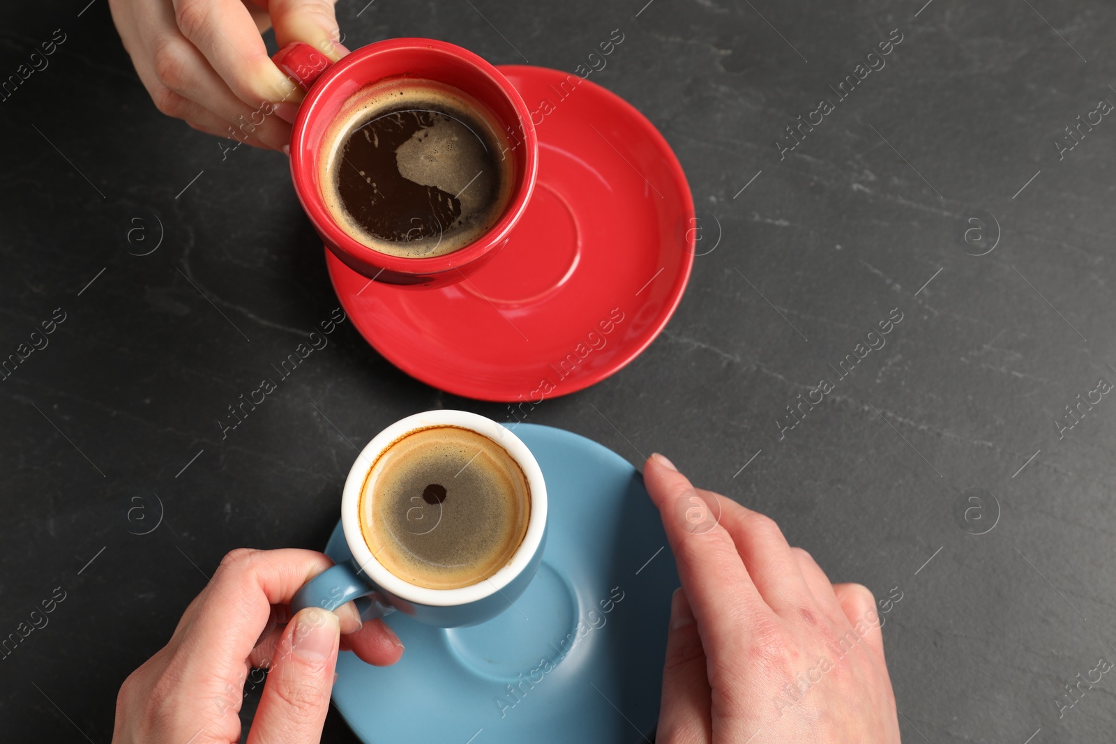 Photo of Women having coffee break at dark textured table, above view. Space for text