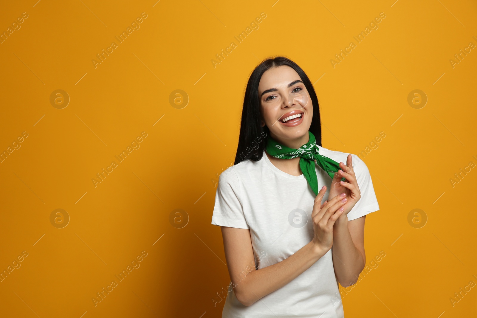 Photo of Young woman wearing stylish bandana on orange background, space for text