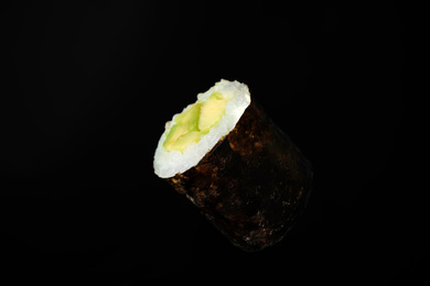 Photo of Sushi roll with avocado on black background