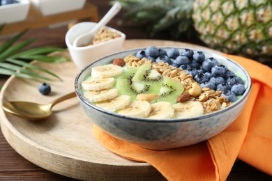 Photo of Tasty smoothie bowl with fresh fruits and oatmeal served on table