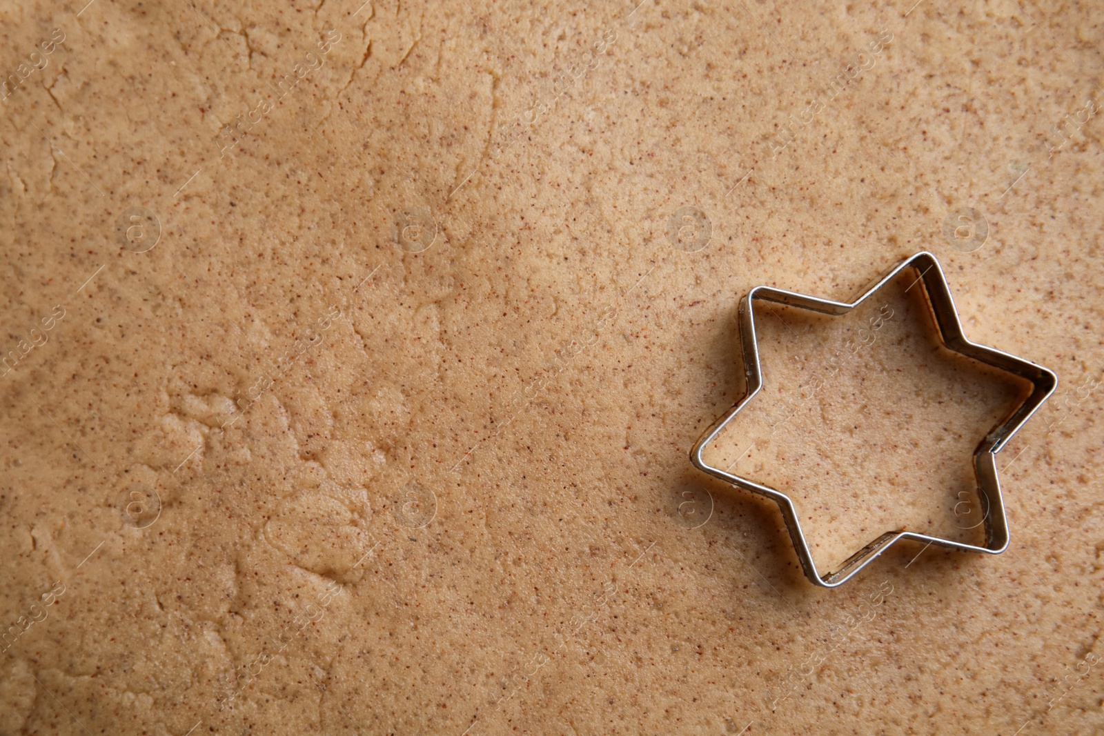 Photo of Homemade Christmas biscuits. Cookie cutter on raw dough, top view
