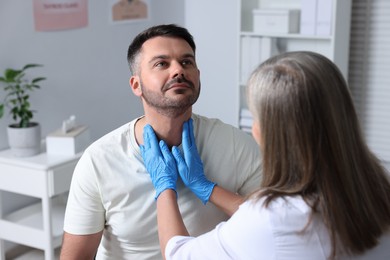 Photo of Endocrinologist examining thyroid gland of patient at hospital