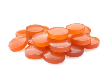 Many orange cough drops on white background