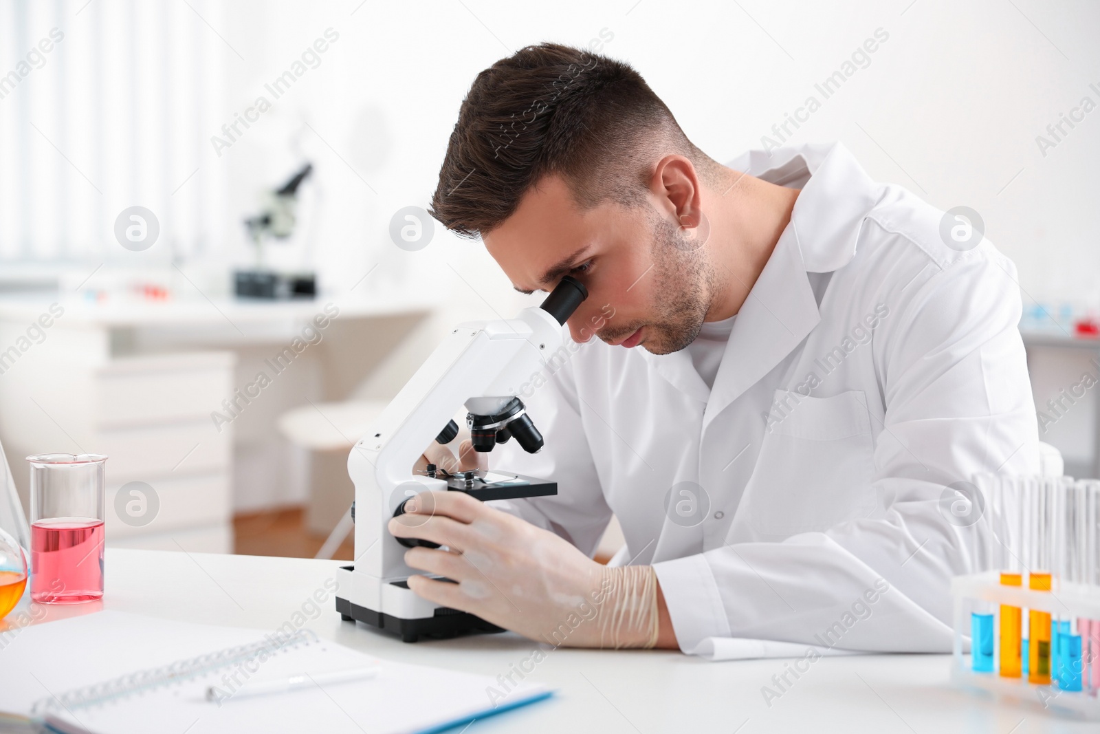 Photo of Scientist using modern microscope at table. Medical research