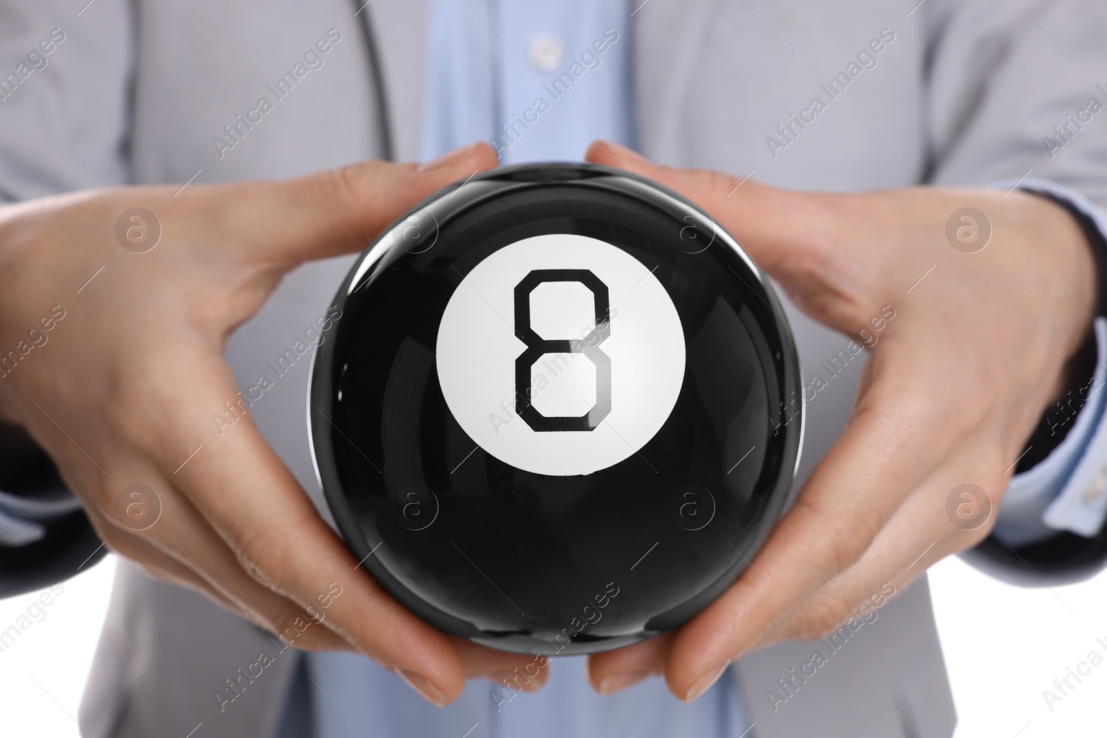 Photo of Man holding magic eight ball on white background, closeup